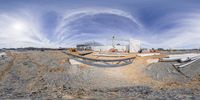 this is a fish eye view looking over a construction area with pipes and concrete structures