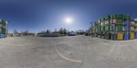 a fish eye view of buildings from the bottom up into the street with the sun shining through