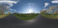 the view from the camera pano of an empty street that leads to a fenced in farm