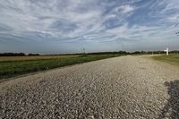 two large grain bins sit in the center of a field, surrounded by silos