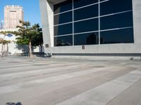 a white and grey brick building with lots of windows and a skateboarder on the sidewalk