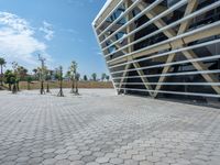 a walkway between the two buildings, next to trees and some bushes in front of each other