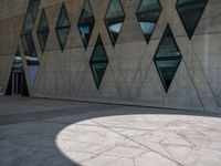 a sidewalk has many shapes, and shadows on the ground in front of it on a sunny day