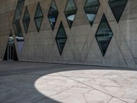 a sidewalk has many shapes, and shadows on the ground in front of it on a sunny day