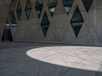 a sidewalk has many shapes, and shadows on the ground in front of it on a sunny day