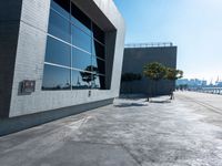 an empty parking lot with a building behind it on a sunny day with blue skies