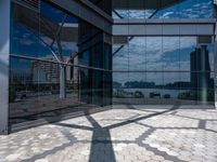 a shadow of a person standing on the sidewalk next to an empty building in front of glass windows