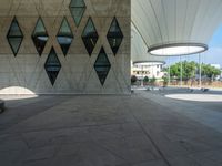 a large concrete building with a lot of windows on the sides and a stone walkway