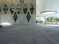 a large concrete building with a lot of windows on the sides and a stone walkway