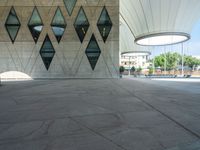 a large concrete building with a lot of windows on the sides and a stone walkway