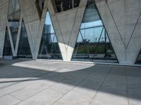 there is a very modern structure with geometric designs on the exterior of it, and a few glass windows