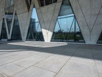 there is a very modern structure with geometric designs on the exterior of it, and a few glass windows