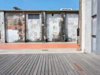 a red fire hydrant sits on a wooden deck in front of a building with an old wall