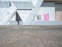 there is a building that is in a city with a pink door outside of it