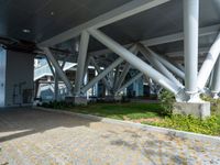 a brick pathway leads from an airport building towards the ground below it there is grass