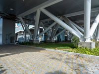 a brick pathway leads from an airport building towards the ground below it there is grass