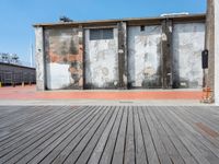 old factory building with cement pillars and a brick wall with metal rods on it in an area with wood floors