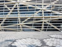 a person in front of a very large building with metal lines on it's side