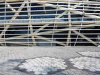 a person in front of a very large building with metal lines on it's side