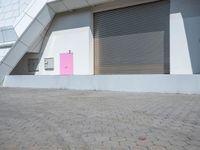 this is an image of a building with shutters and a pink door on it