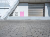 a red stop sign in front of a building with some pink shutter doors in front of it