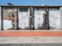 a sidewalk outside of an old building with peeling paint on the cement, and a window