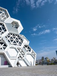 a building with many cubes in front of it and some trees in the background