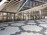 there is a walkway inside an enclosed area of a building that has windows and hexagon tiles on the ground