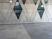 the white tiled floor is filled with some geometric shapes and windows on it's side