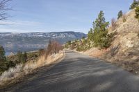 the road near a mountain is empty and has no traffic or people on it,