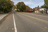 a street in an neighborhood that appears to have leaf fallen on the side of the road