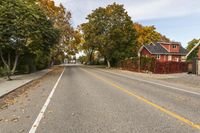 a street in an neighborhood that appears to have leaf fallen on the side of the road