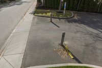 a yellow street pole on the side of the road next to a sidewalk that has a broken sign hanging off it