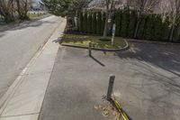 a yellow street pole on the side of the road next to a sidewalk that has a broken sign hanging off it