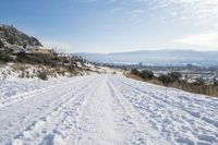 a man is cross country skiing in the snow outside on a sunny day and hills and mountains are in the background