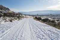 a man is cross country skiing in the snow outside on a sunny day and hills and mountains are in the background