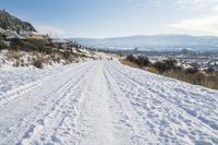 a man is cross country skiing in the snow outside on a sunny day and hills and mountains are in the background