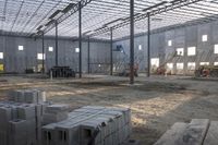 a building under construction with several stacks of cinder blocks in it on the ground outside