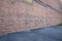 an empty parking lot next to a brick building with graffiti painted on it with the words yes and two different colors