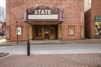 a building with a sign in the doorway of it saying state theatre in a city