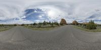 a panoramic photograph of an empty road in a scenic area under a cloudy sky