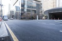 an empty street near an office building with glass walls and white stripes on the sidewalk