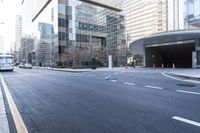 an empty street near an office building with glass walls and white stripes on the sidewalk