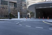 an empty street near an office building with glass walls and white stripes on the sidewalk