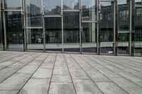 an empty brick floor and glass buildings behind it with a stop sign above the floor