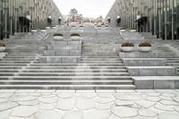 a large group of concrete steps that lead down to many buildings with pots of flowers