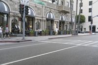 people walking on the sidewalk by a coffee shop in the city streets of san francisco