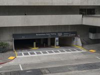 an airport has several signs in its parking garage while people walk by the walkway and stairs on the right