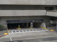 an airport has several signs in its parking garage while people walk by the walkway and stairs on the right