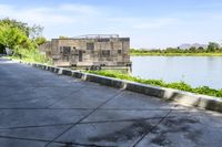 a boat in a lake floating on top of a cement block wall by the edge of the road